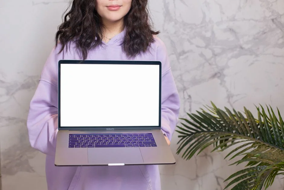 Une maquette de site web affichée sur l’écran d’un MacBook posé sur un bureau au travail.